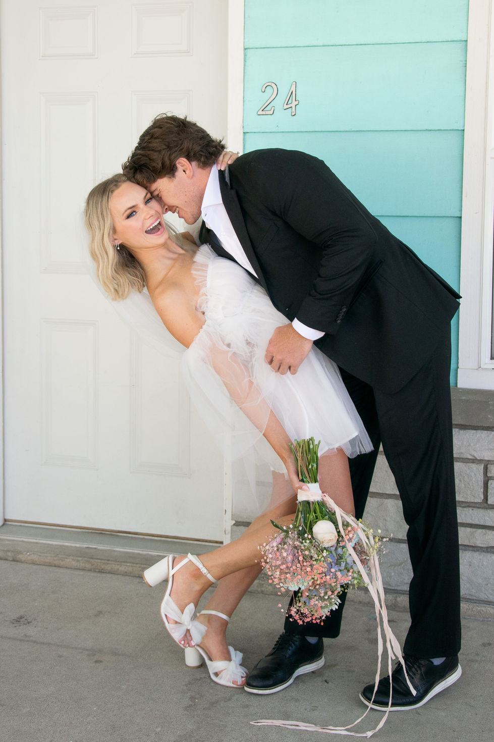 bride laughing while groom dips her