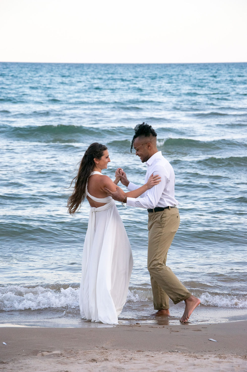 casual bride and groom dancing in shallow water in Lake Michigan — wedding photography by Shutter & Sojourn
