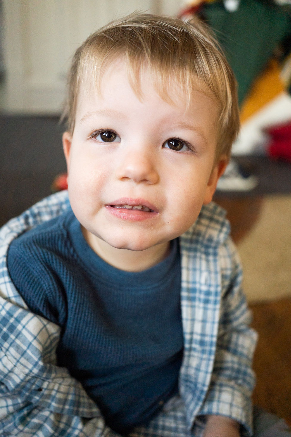 toddler boy smiling at camera in disheveled flannel top — newborn photography by Shutter & Sojourn
