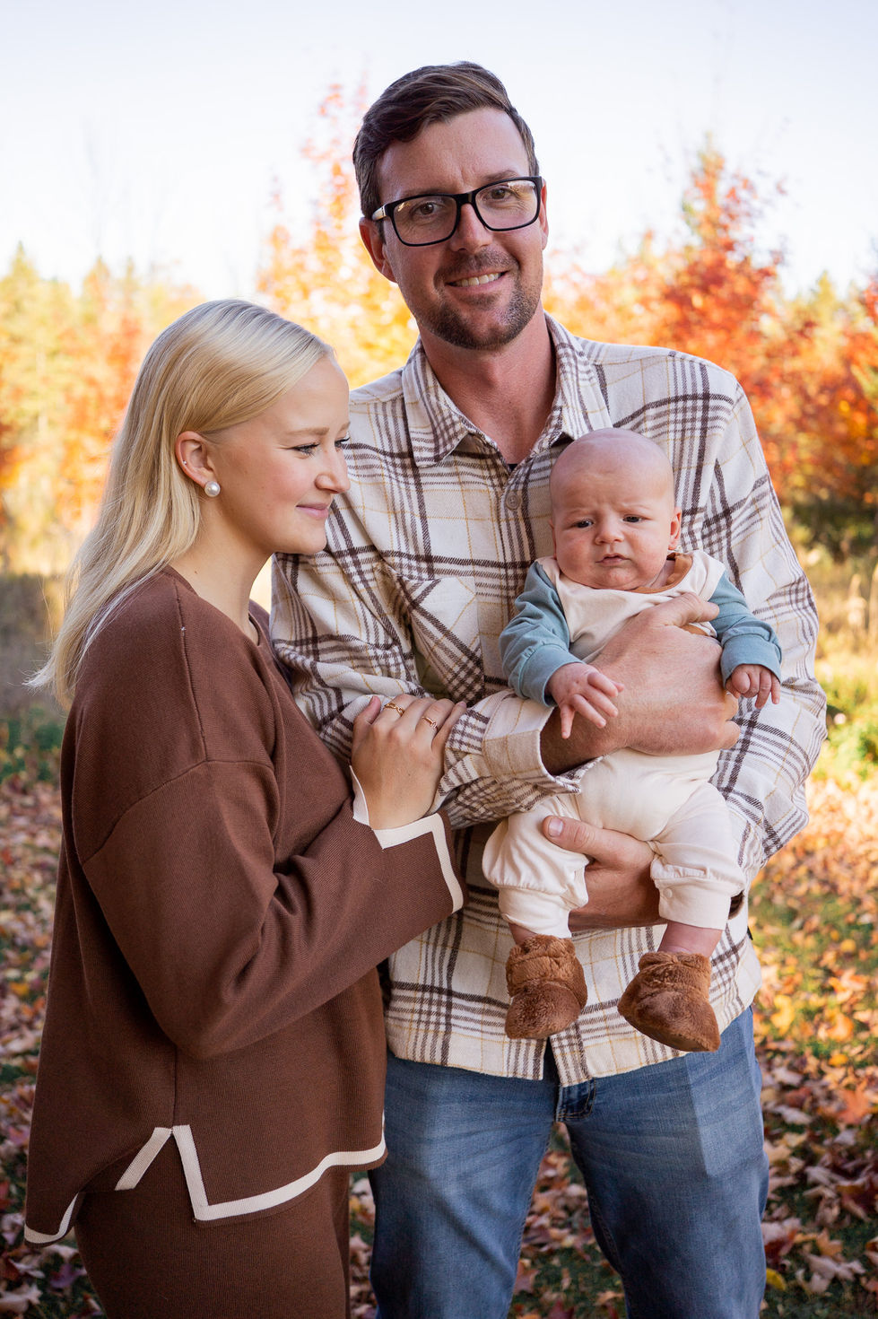 dad holding baby and smiling at the camera while mom smiles baby — family photography by Shutter & Sojourn