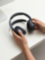 Mãos segurando fone de ouvido em loja online de acessórios para celular.
