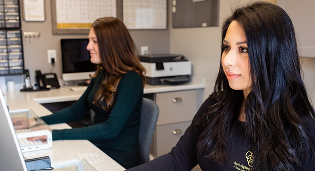 Two woman working on the computers at the front desk in our West Haven office