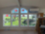 New windows in a gallery wall overlooking a green lawn.