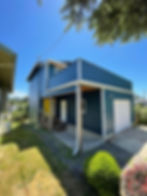 Modern blue home exterior gallery with yellow door.