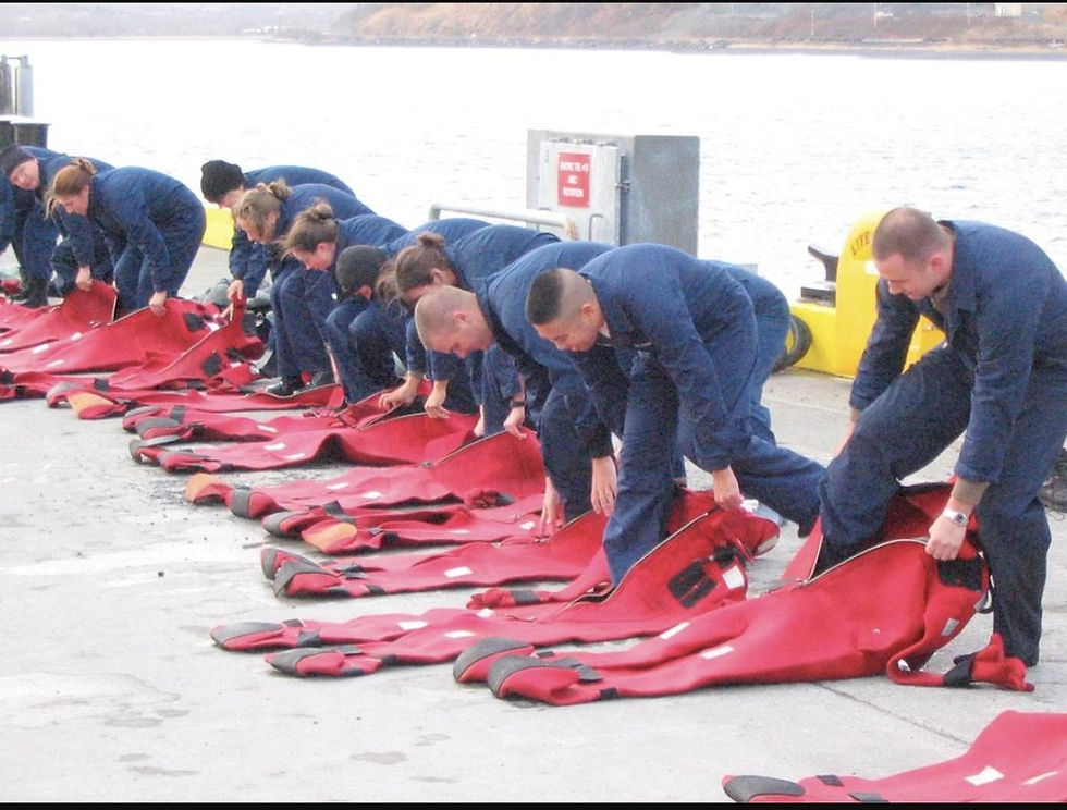 Crew members practicing immersion suit donning on a pier