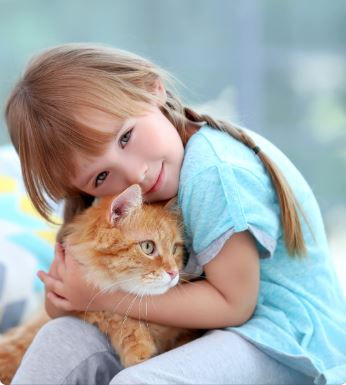 young girl hugging kitten