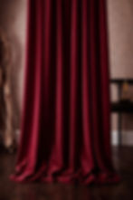 Bordeaux red velvet curtains in a classic European interior, shown floor-length with rich texture and deep colour.