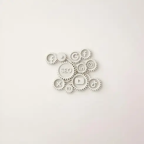 Viele weiße 3 D Zahnräder verzahnt ineinander auf denen unterschiedliche Symbole von Social Media und das Wort SEO sichtbar sind. Titelbild für Strategie und Beratung
