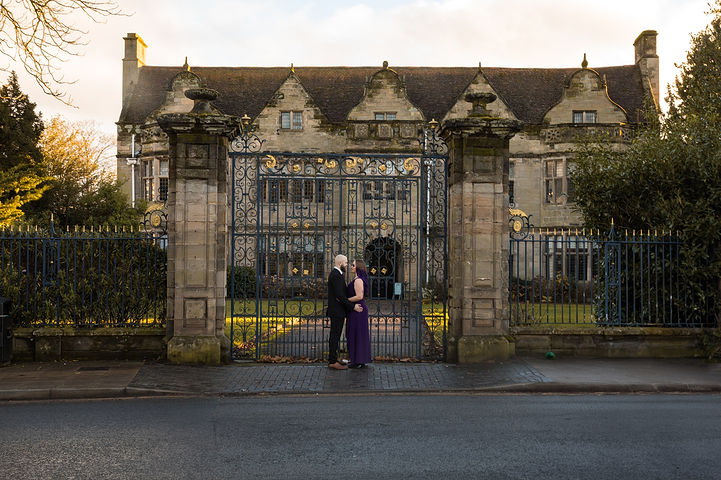 Couple stand by the gate into St Johns House in Warwick