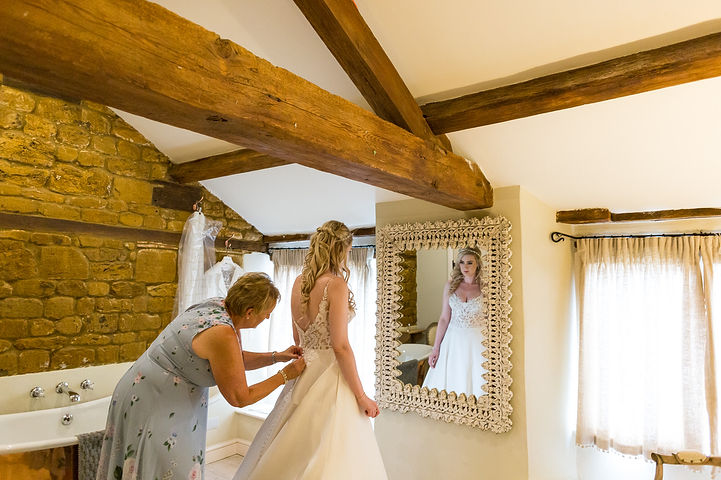 Bride is buttoned into her dress