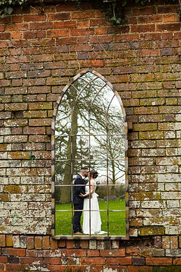 Bride and groom kiss in the reflection of a mirror at Dodmoor House