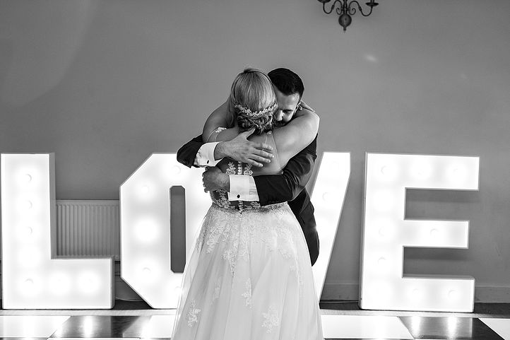 Bride and groom have their first dance with LOVE letters in the background