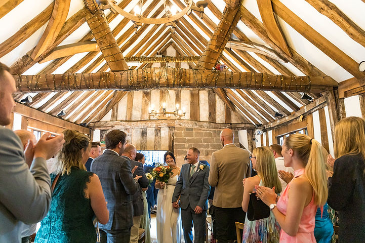 Bride and groom walk down the aisle at The Black Prince Room at Cheylesmore Manor