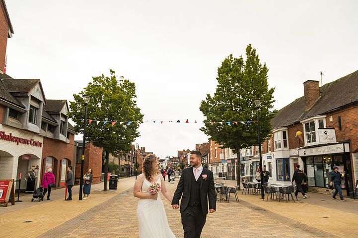 Couple walk holding hands through the streets of Stratford-upon-Avon