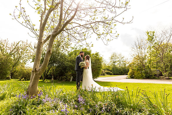 Birde and groom pose in the spring bluebells at Dodmoor House