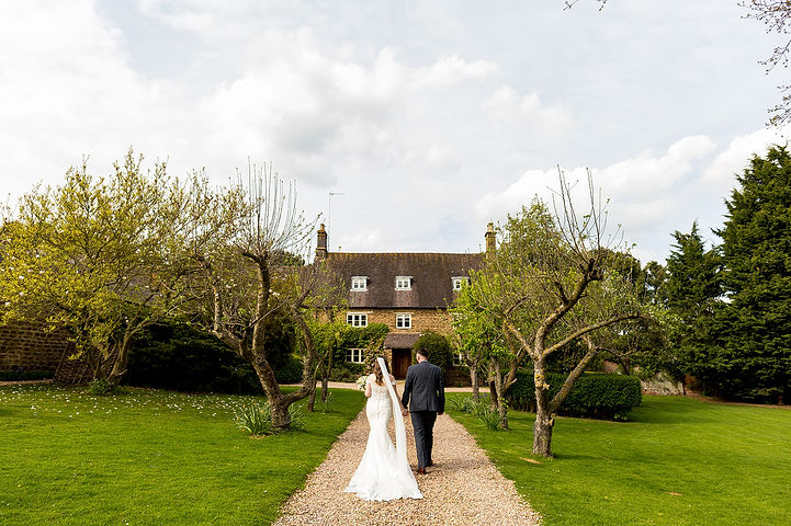 Bride and groom walk down the lane towards Dodmoor House