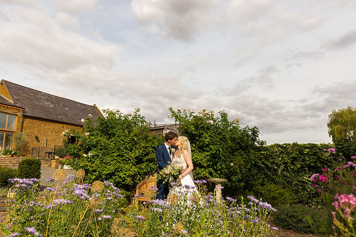 Bride and groom kiss in the gardens at Crockwell Farm