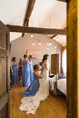 Bride getting into her dress in the honeymoon suite at Dodmoor House