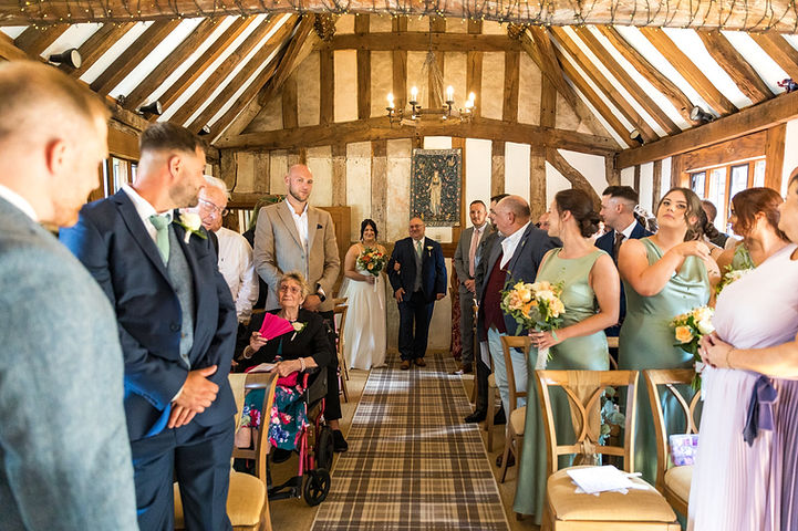 Bride walks down the aisle with her father in The Black Prince Room at Cheylesmore Manor