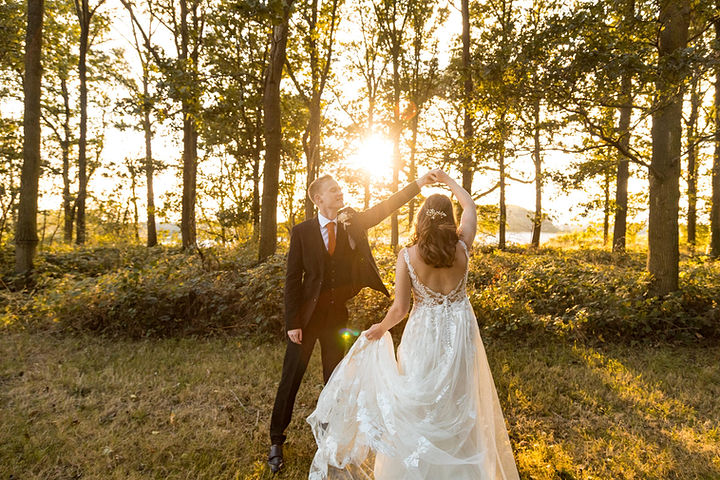 Groom spins Bride in the golden hour sunset at Swallows Nest Barn Wedding