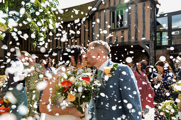 Couple kiss with confetti at Cheylesmore Manor