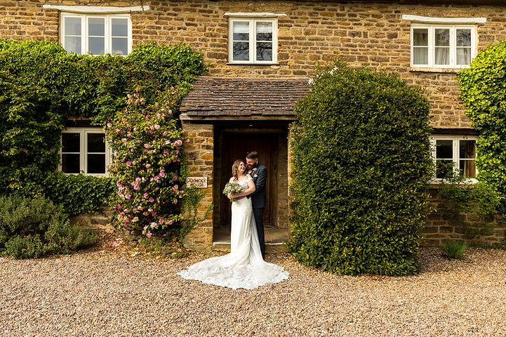 Couple pose in front of Dodmoor House
