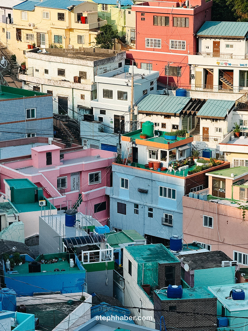 Colorful hillside houses with blue, pink, and green rooftops in a densely packed neighborhood. Gamcheon cultural village, Busan