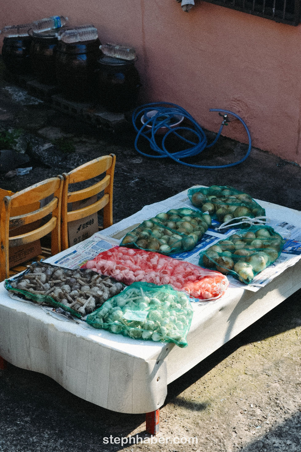 Table with bags of seafood and two chairs.