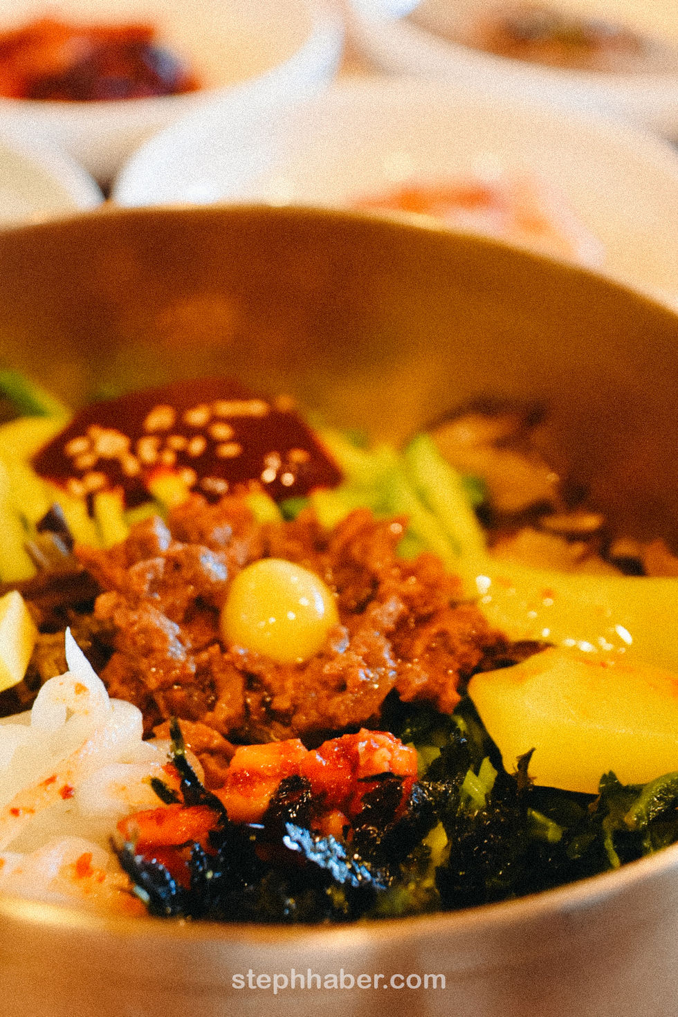 Colorful Korean bibimbap with various toppings in a bowl.