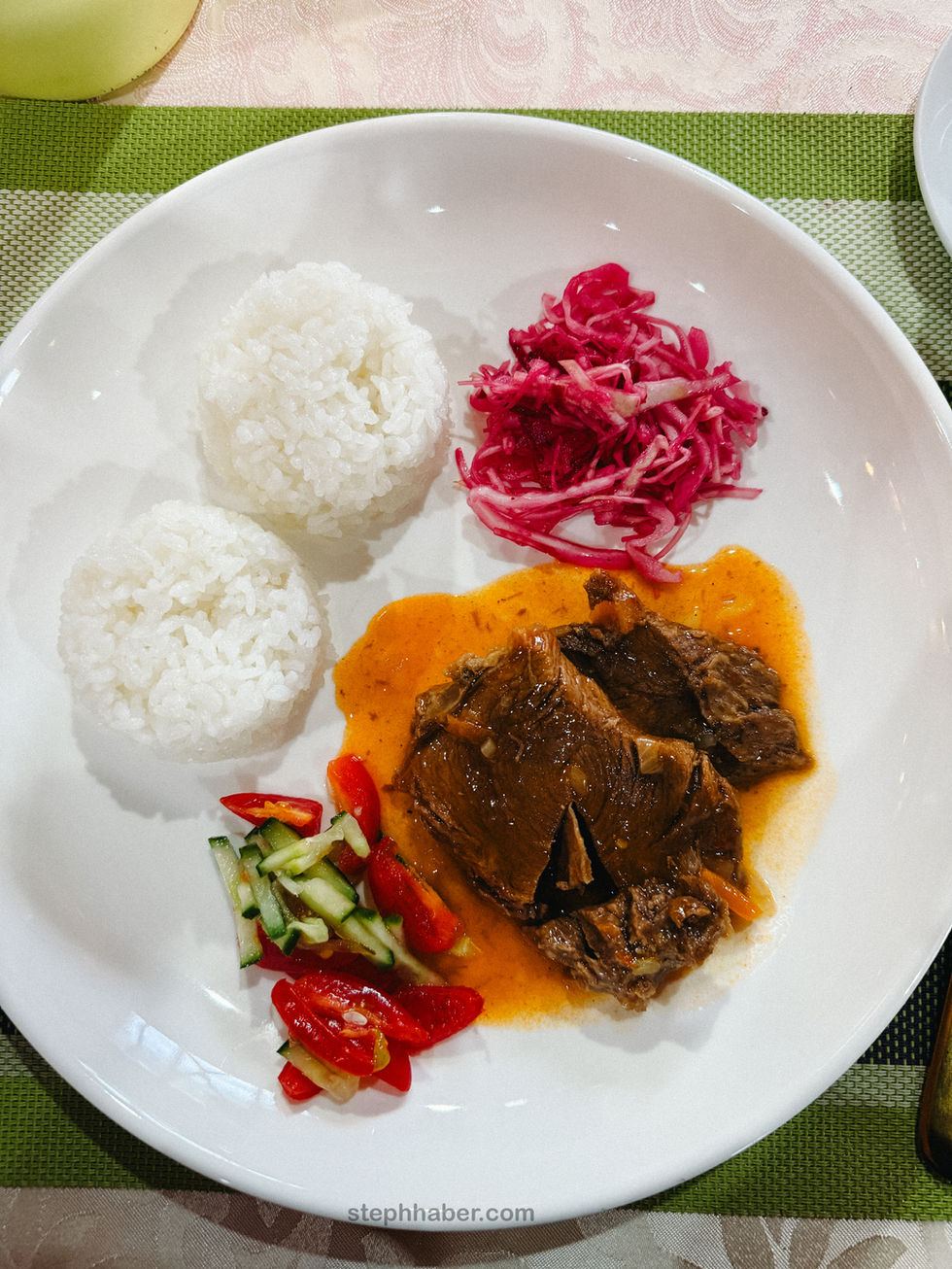 Plate with rice, beef, salad, and pickled cabbage.