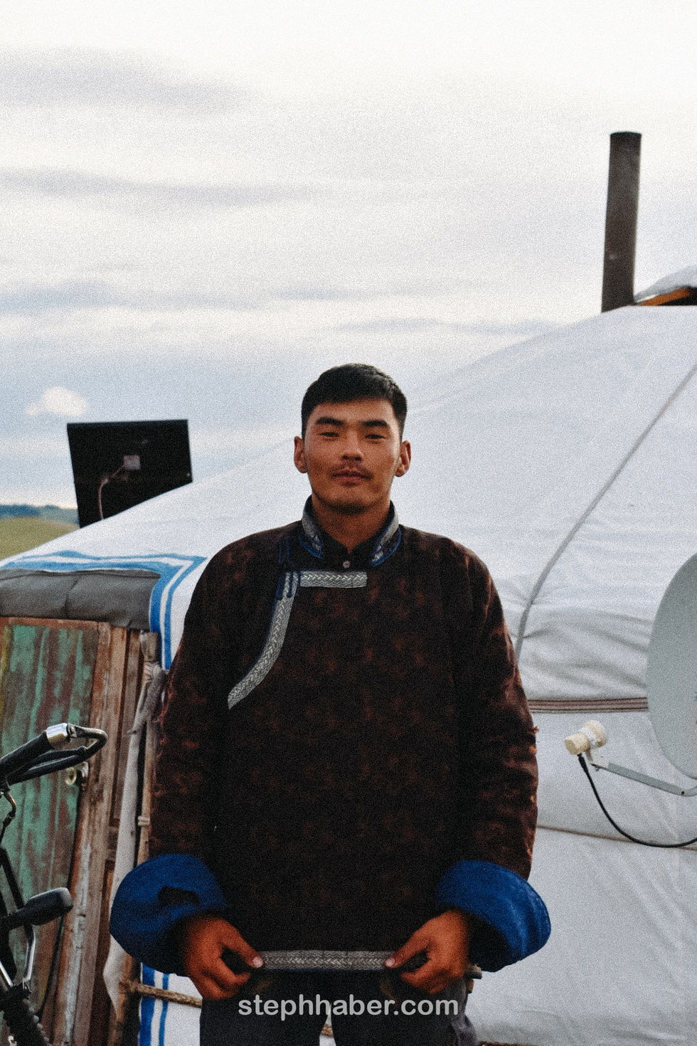 A person stands outside near a yurt.