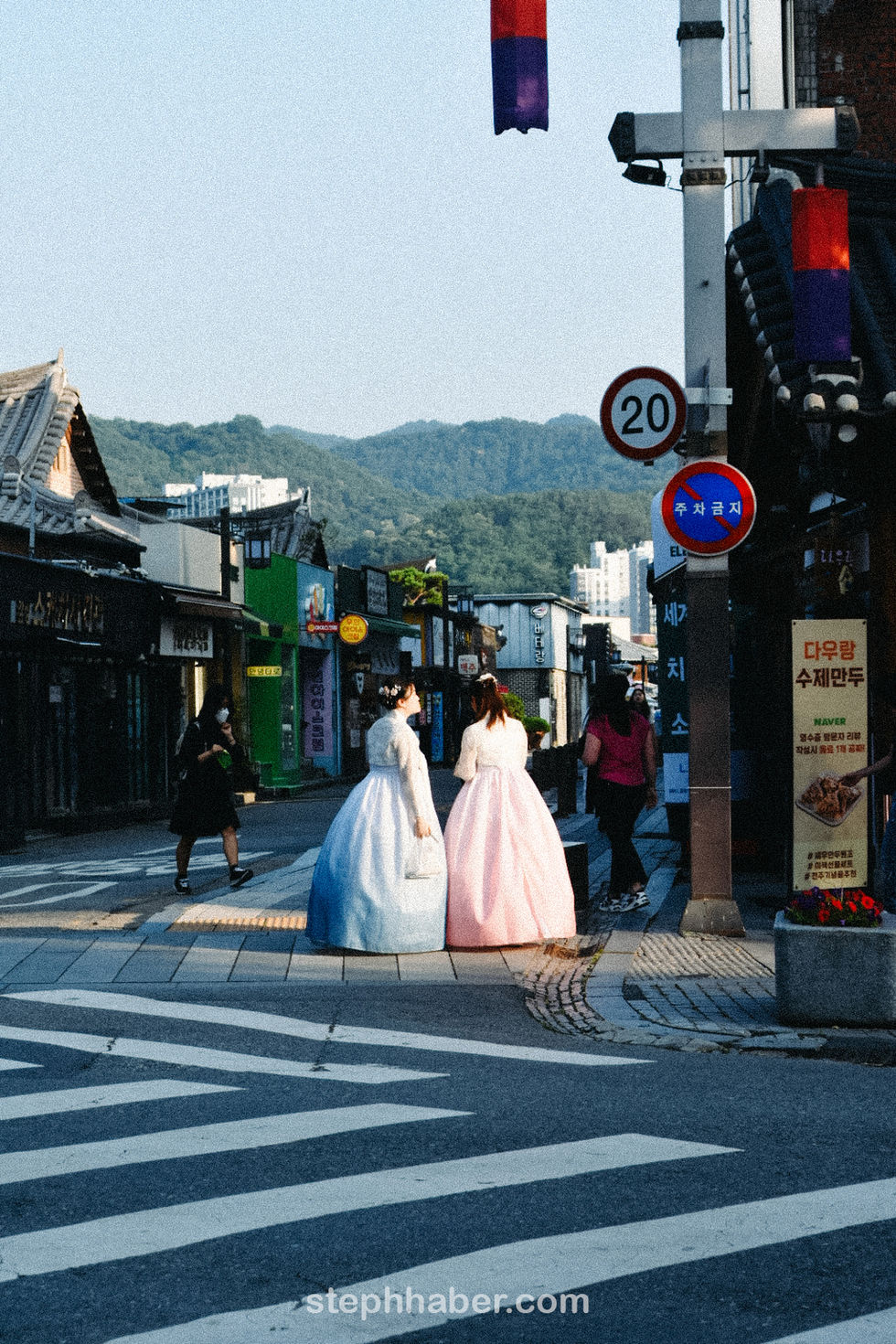 Two people in traditional attire on a street.