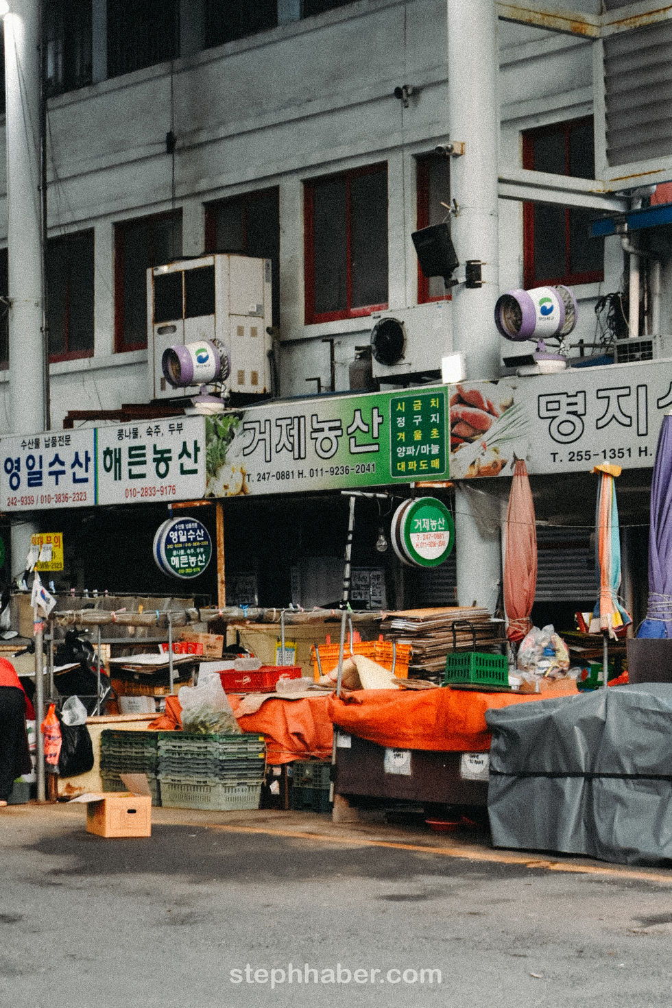 Outdoor market with various colorful stalls and signs.