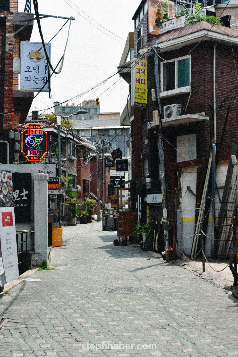 Narrow urban alley with signs and buildings.