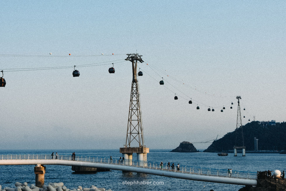 Cable cars over water with distant islands.