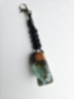 Handmade Teak wood and resin keychain pendant with light green and white design.