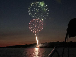 Fireworks over the lake at sunset.