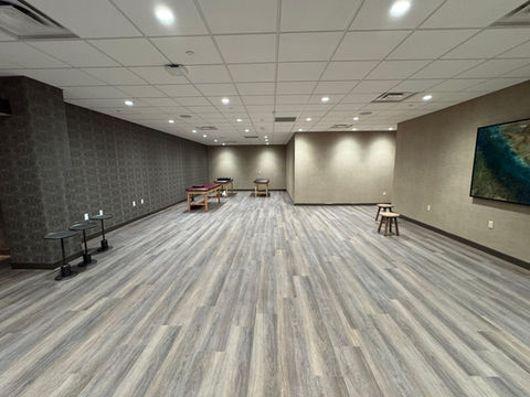 Worker installing new hardwood flooring in a residential property in Charlotte, NC.