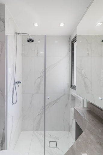 Banheiro do quarto de casal com acabamentos e soluções funcionais em apartamento na Vila Prudente, São Paulo.