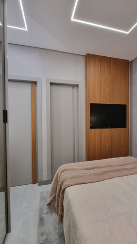 Quarto de casal com decoração personalizada e soluções de aproveitamento de espaço no Condomínio Infinity Vila Matilde.