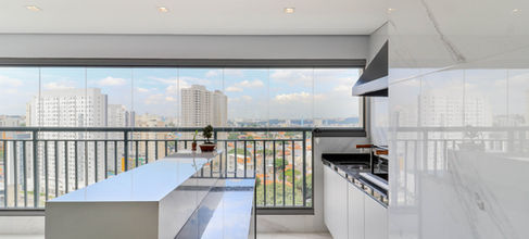Varanda gourmet com mobiliário planejado e soluções funcionais no apartamento decorado Panorâmico Vila Prudente.