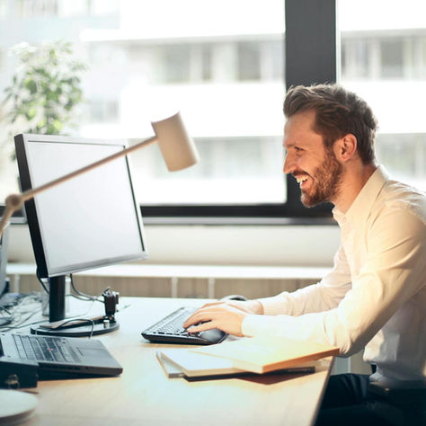 A man in a white shirt at his desk doing an online compliance course