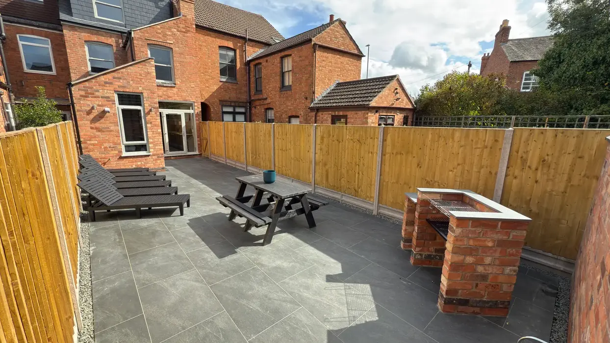 Private outdoor space in student house with loungers, seating, BBQ and bike storage.