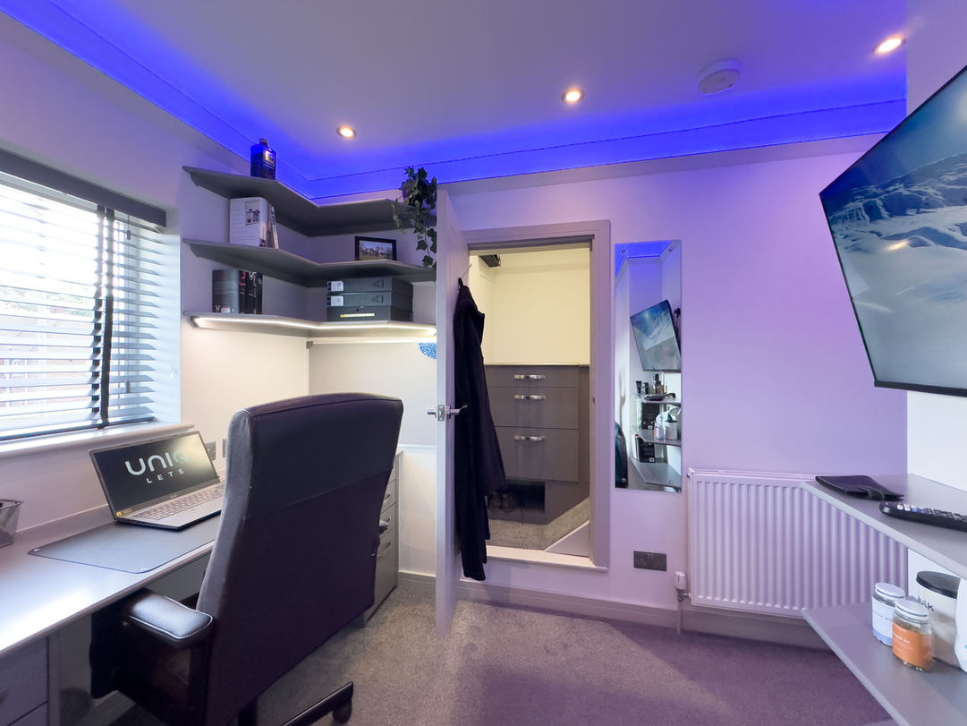 Student accommodation bedroom with built-in desk, shelving and wardrobe