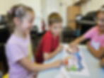 Piano tutor teaching happy students