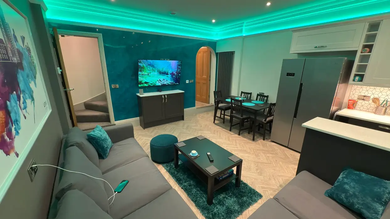 Spacious living room at 11a Park Road with LED ambient lighting and wall-mounted TV.