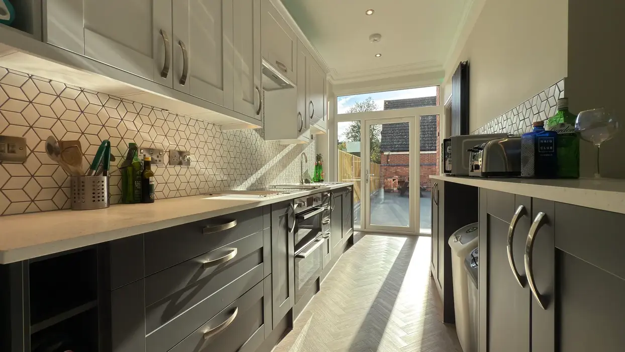 Modern kitchen with integrated appliances, LED under-cabinet lighting, and breakfast bar.