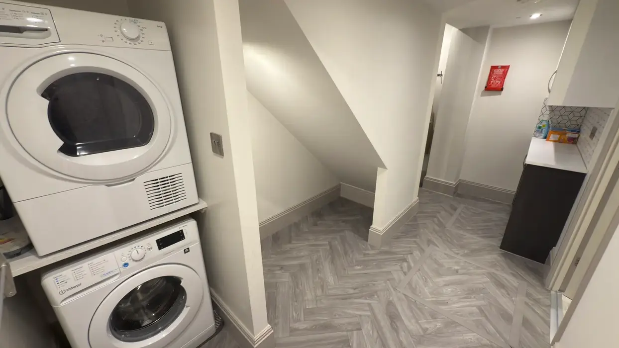 Student housing utility room with washer, dryer and storage.