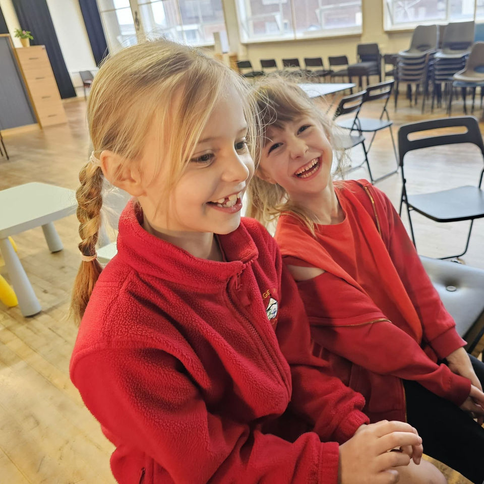 Two young students laughing and playing piano