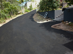 Rejuvenated asphalt driveway after resurfacing — looking like new